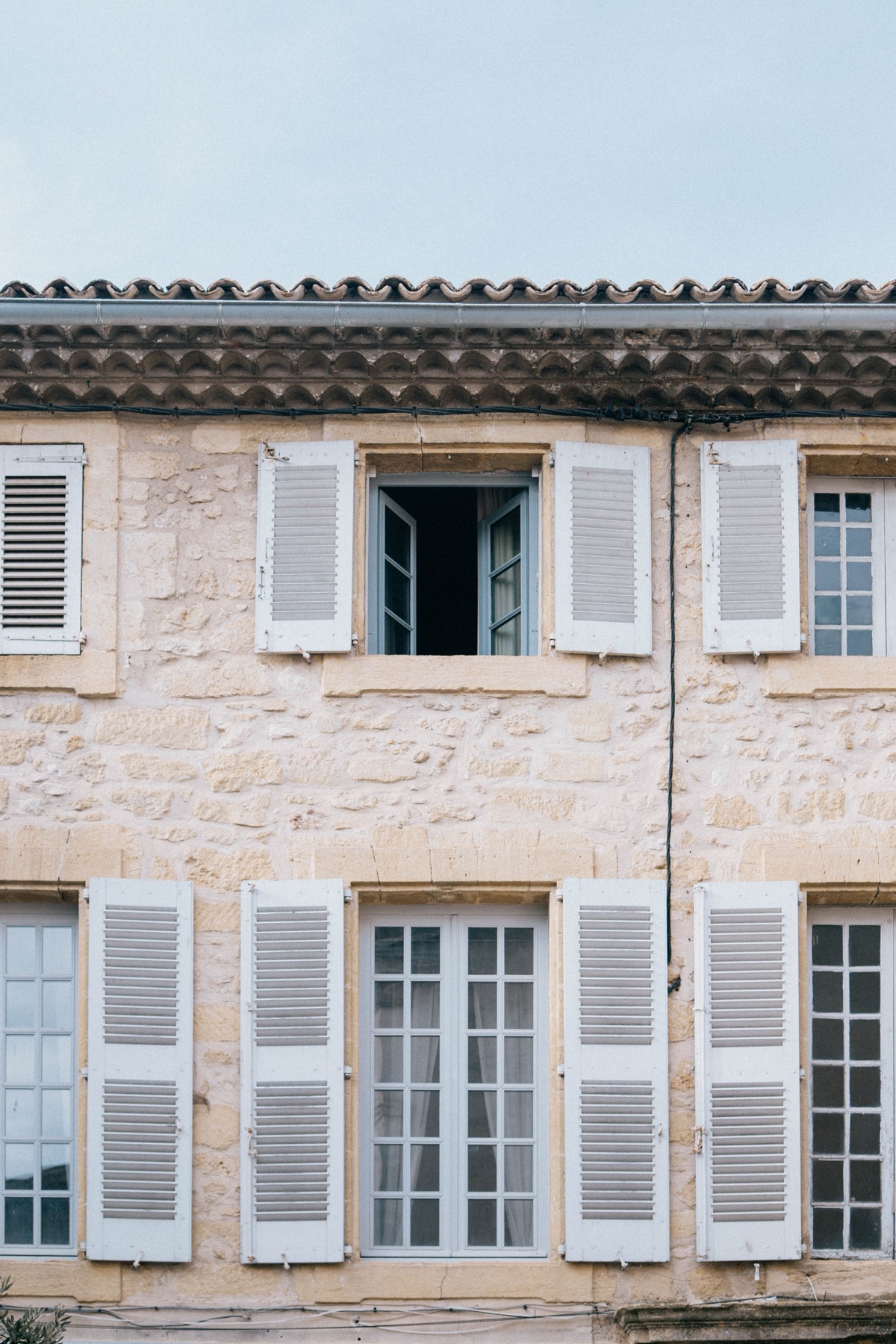 Façade provençale en pierre aux volets blancs